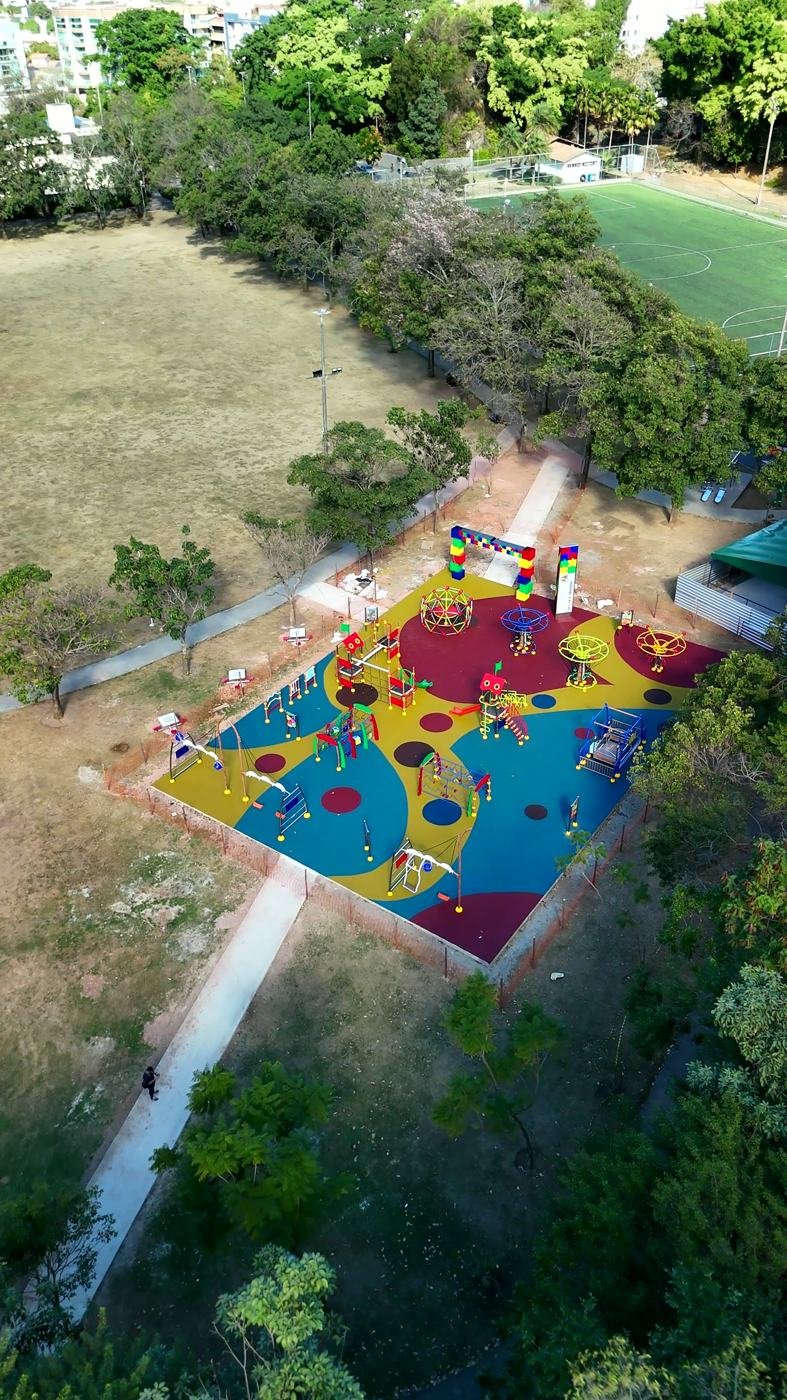 Praça inclusiva com piso emborrachado integrada ao parque arborizado